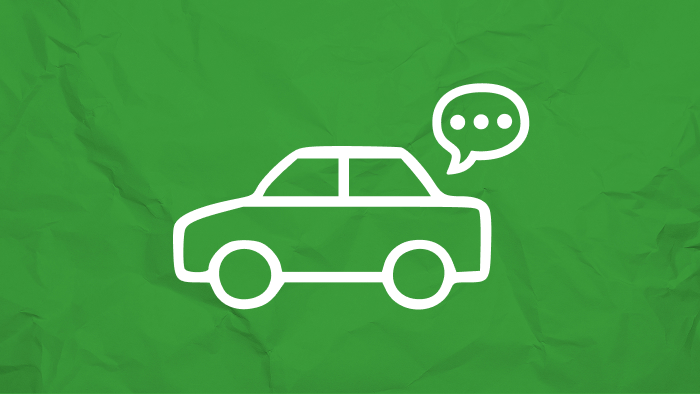 Outline of a car with a speech bubble on a green crumpled background.