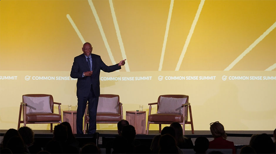 Geoffrey Canada on stage in front of yellow screen